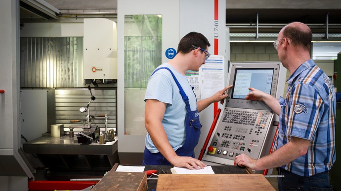 Ein Teilnehmer mit seinem Ausbilder in der Werkstatt