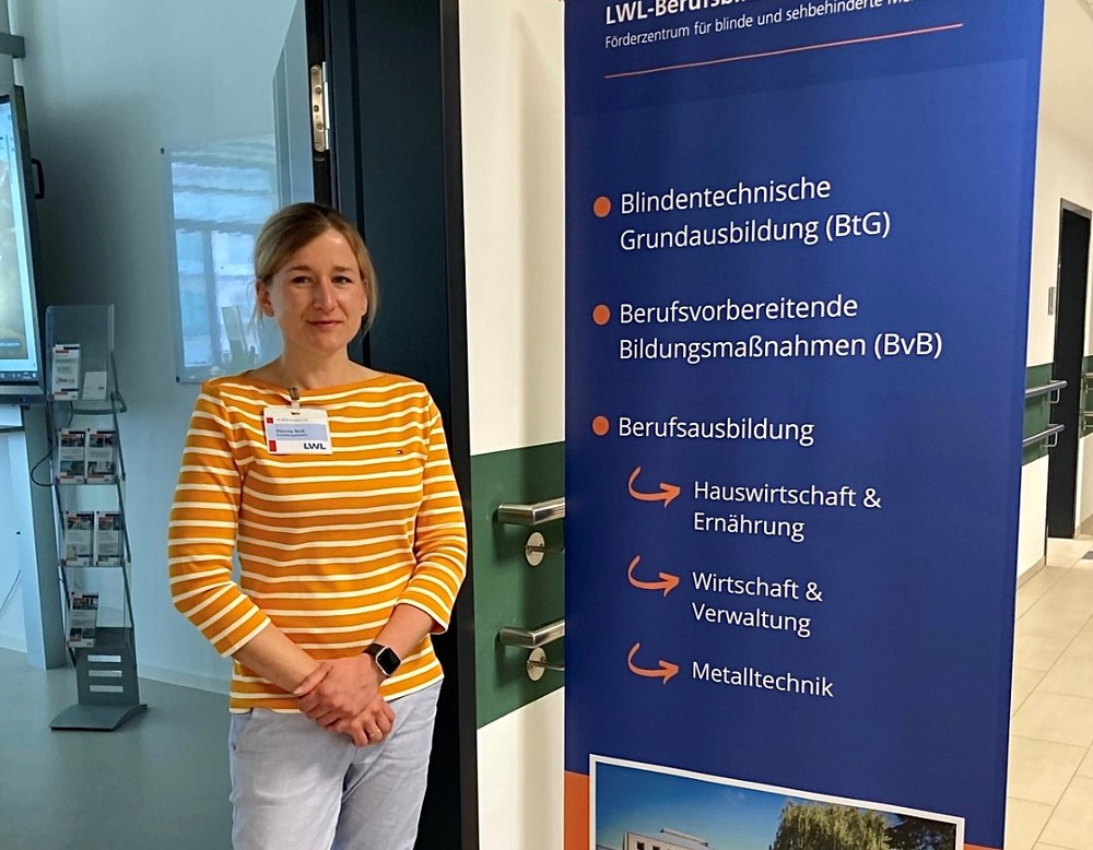 Désirée Reiß neben einem Aufsteller mit Infos zum BBW Soest