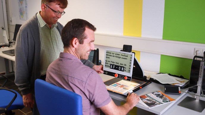 Ein Ausbilder betreut einen Teilnehmer bei der Arbeit am Computer