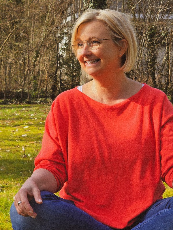 Monique im Schneidersitz vor einem Baum