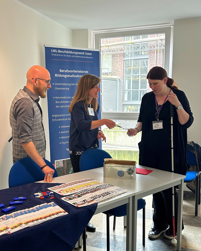Am Stand mit drei Personen